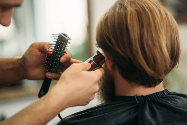 istock Bearded Man having a haircut with a hair clippers 935993250