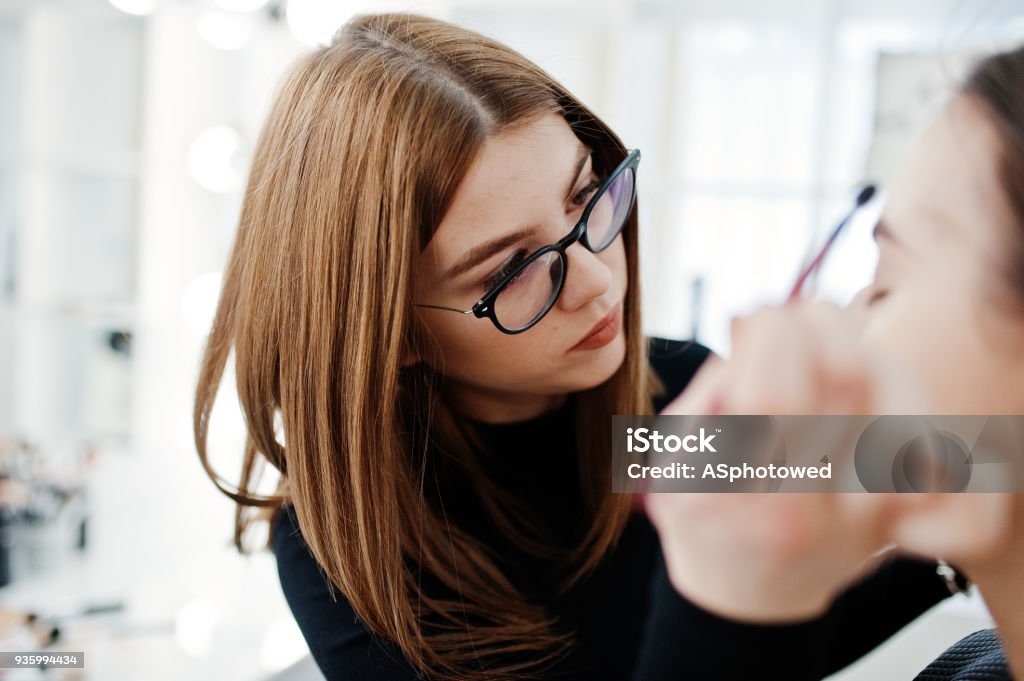 Make up artist work in her beauty visage studio salon. Woman applying by professional make up master. Beauty club concept. Adult Stock Photo