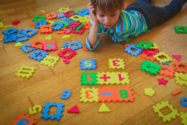 istock little boy playing with puzzle, education concept 935994526
