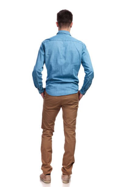 back view of a man standing with hands in pockets back view of a casual man standing with hands in pockets on white background rear view stock pictures, royalty-free photos & images