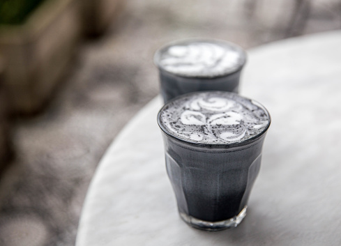 Two charcoal super latte on marble background. Trendy healthy organic drink
