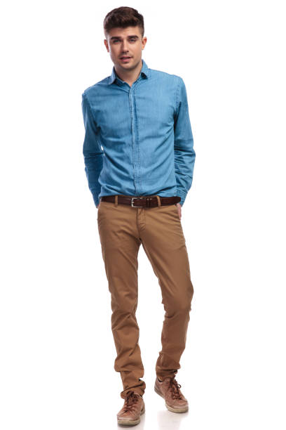 istock smiling casual man standing with hands in his back pockets 936000588
