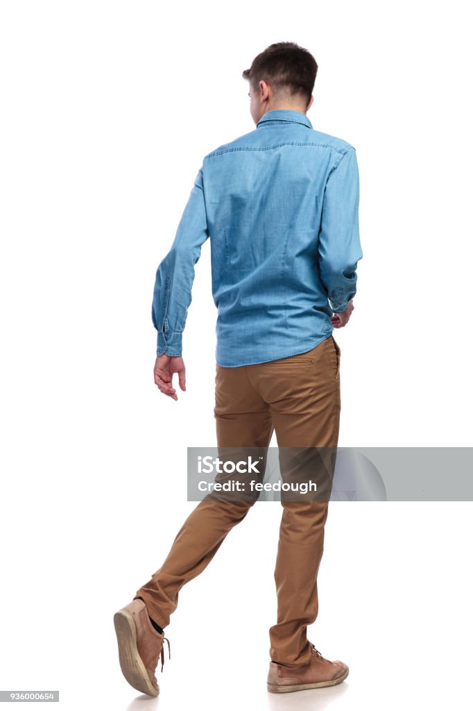 back view of a walking casual man looking to side back view of a walking casual man looking to side on white background Walking Stock Photo