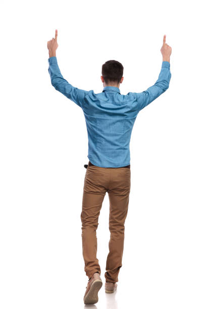 istock back view of a casual man walking and pointing up 936000774