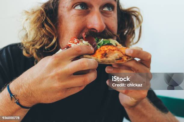 Man Eating Pizza In A Restaurant Stock Photo - Download Image Now - Eating, Pizza, Food