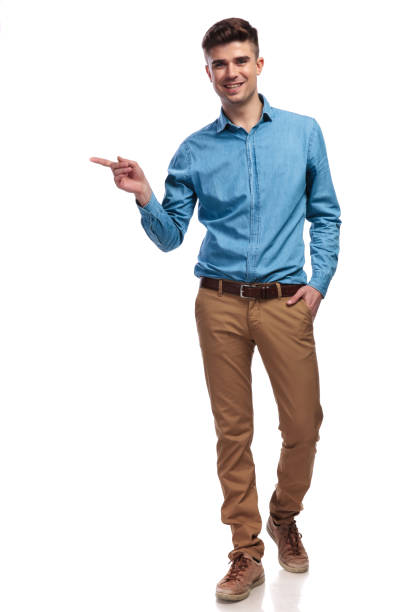 istock happy young casual man pointing finger to side 936000936