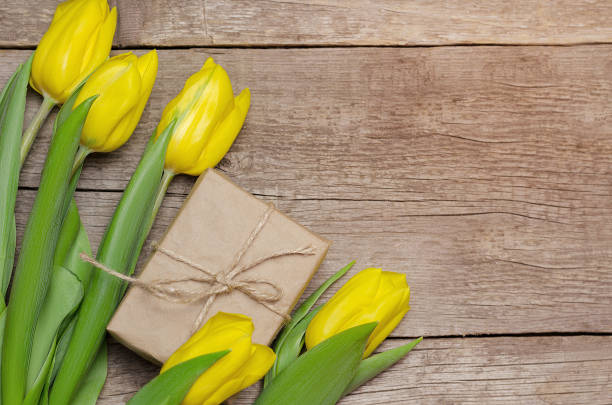 istock Yellow tulips and gift box on wooden background 936005050