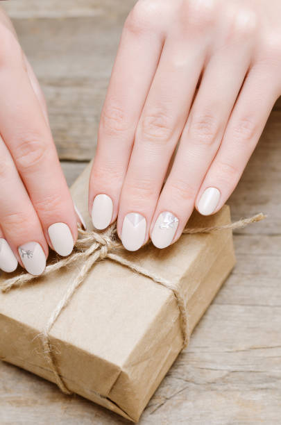 istock Female hands with beige nail design 936007164