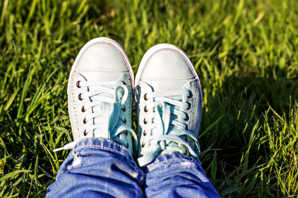 istock Female legs in a clearing with green grass. 936007350