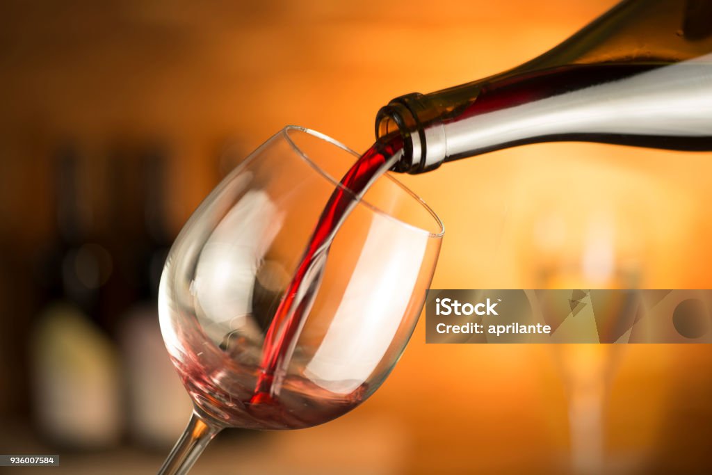 Glass with red wine Bottle is pouring red wine in a glass Wine Stock Photo