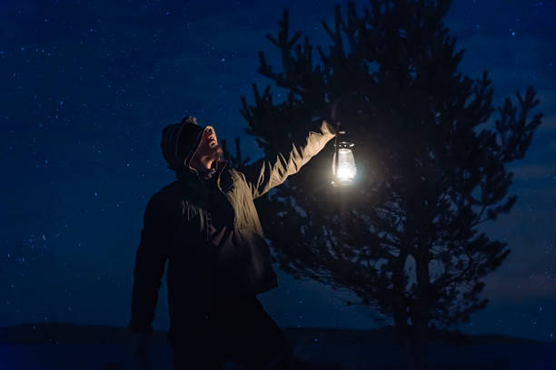 istock Man holding gas lamp in forest at night 936007804