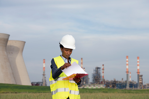 Female engineer writing report of the Fossil fuel power station.