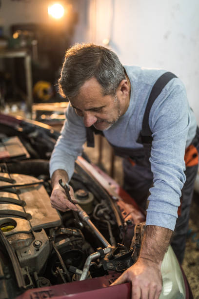 istock Male mechanic fixing car at car service 936008540