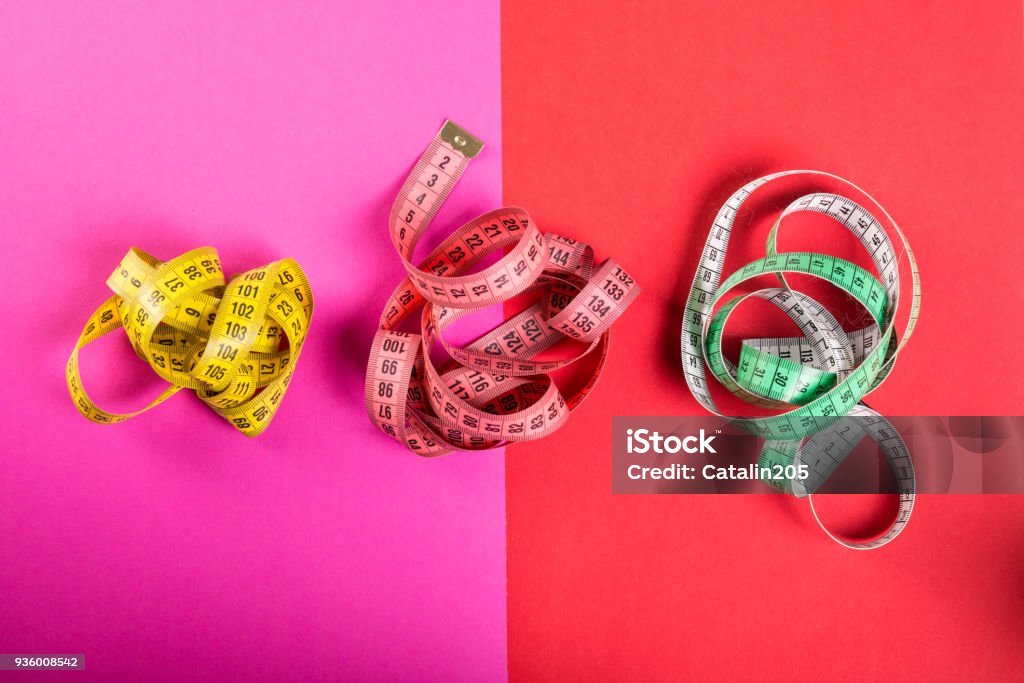 Three measuring tape on red and pink background Centimeter Stock Photo