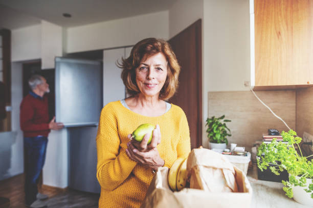 istock Senior couple unpacking food in the kitchen. 936012008