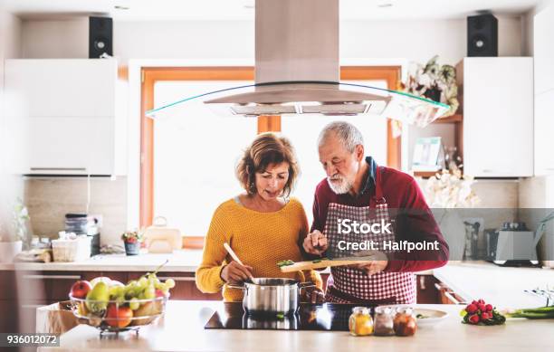 Photo libre de droit de Couple De Personnes Âgées Préparer Un Repas Dans La Cuisine banque d'images et plus d'images libres de droit de Cuisiner