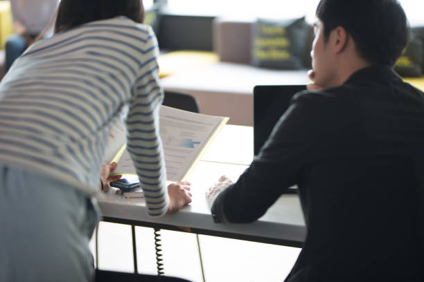 Young Asian people working together in co-working space Young Japanese businessman working in co-working space common room stock pictures, royalty-free photos & images