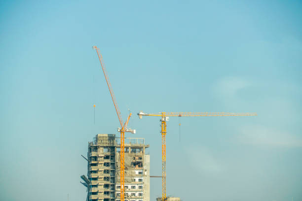 istock Two cranes are building the building with blue sky 936078246