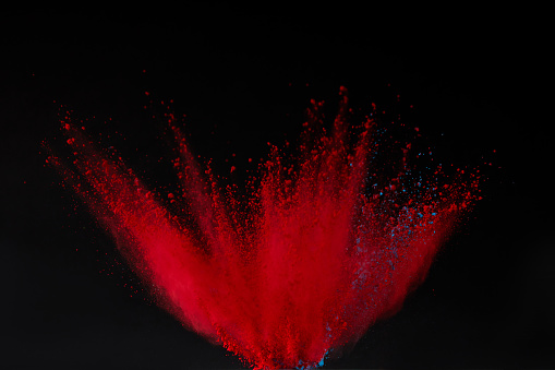 red holi powder explosion isolated on black, festival of colours