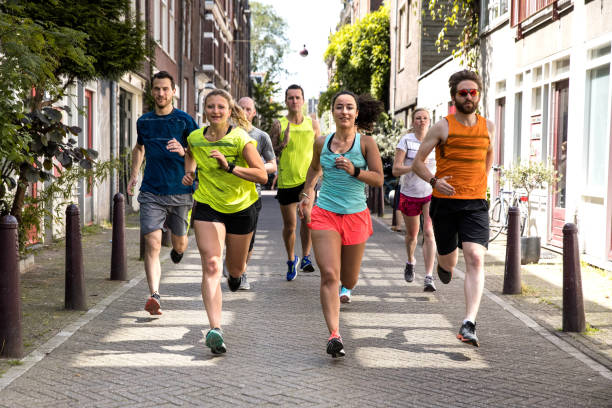urbane läufer mannschaftstraining in der stadt - marathon sport sports training city street stock-fotos und bilder