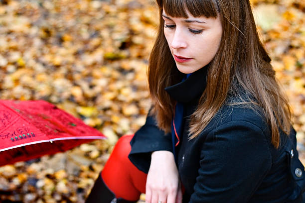 female with umbrella in the park stock photo