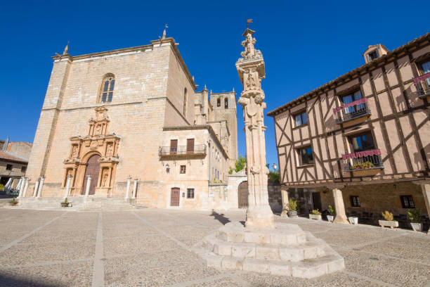 court pillar in Penaranda de Duero main square Rollo or court pillar and Parish of Santa Ana in main square of Penaranda de Duero village, in Burgos, Castile and Leon, Spain, Europe medieval restraints stock pictures, royalty-free photos & images