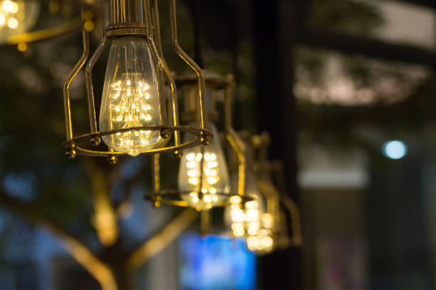 istock LED vintage light bulbs hang on ceiling for room decoration in dark room 936092880