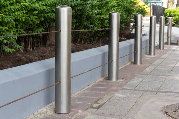 istock stainless steel bollards on concrete pavement beside road 936093000