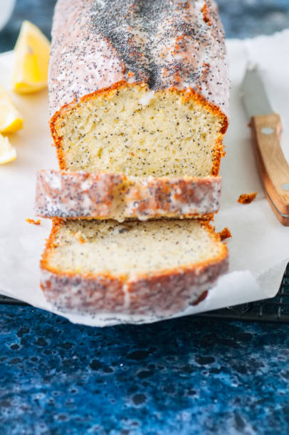 istock Homemade lemon poppy seed pound cake on a wire rack. Blue stone background. Close up. 936093208