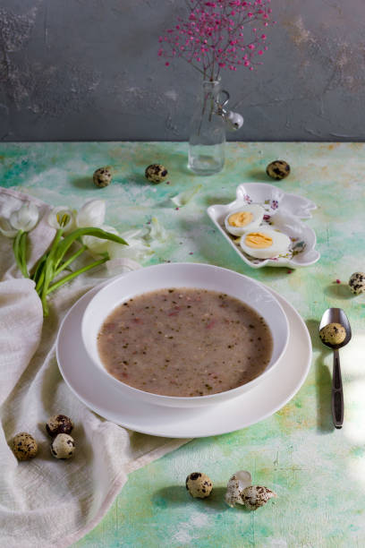 istock Polish traditional sour soup, zurek. Light background, eggs and tulips. White plate. 936093540