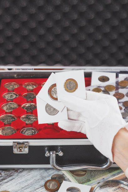 istock Hand in the glove holds flips with collector coins 936093642
