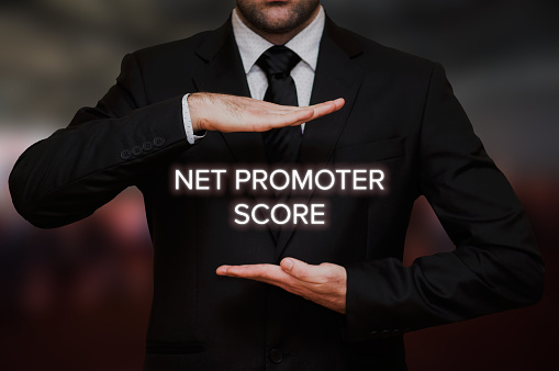 Net Promoter score (NPS) concept text between hands of the businessman, blurry bokeh background