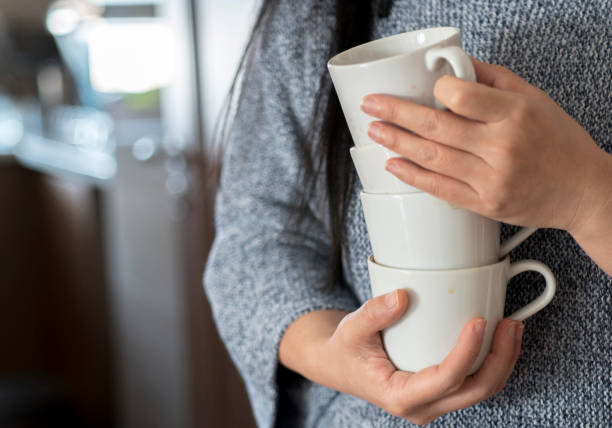 istock girl holding coffee cups to wash 936102212