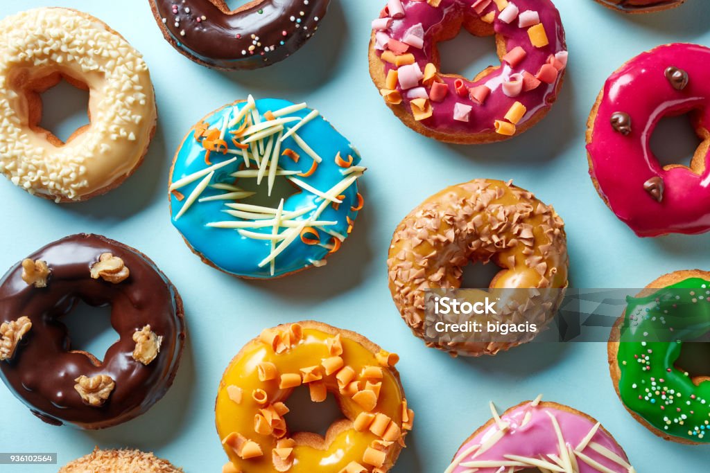 Various donuts on blue background, from above Various colorful donuts on blue background, top view Doughnut Stock Photo