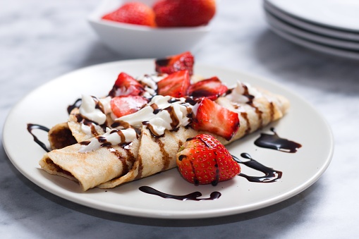 Crepes  filled with strawberry jam and topped with custard and chocolate