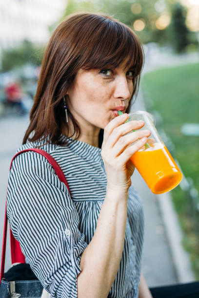 istock Middle-aged woman drinking juice 936106558
