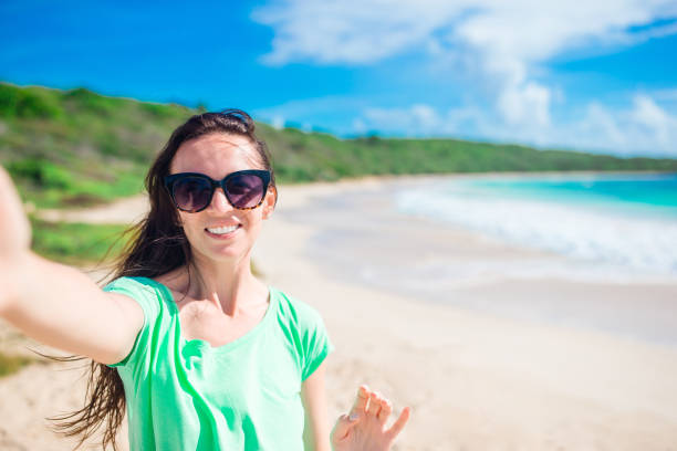 istock Young woman taking selfie portrait background palm tree on the beach 936106686