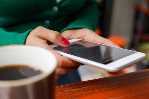 Photo of cup of coffee on table in restaurant near smartphone, morning concept