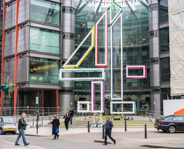 Channel 4 Headquarters in Westminster, London London, UK - Pedestrians on the street in front of the headquarters building of the UK television broadcaster Channel 4, located in Westminster. bbc photos stock pictures, royalty-free photos & images