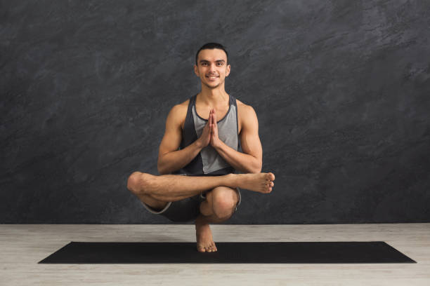 istock Young flexible man practicing yoga at gym 936121698