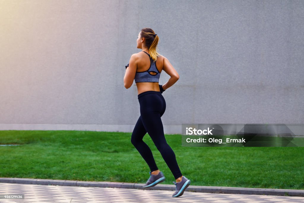 Young beautiful sportive girl runing. view from the back Running Stock Photo