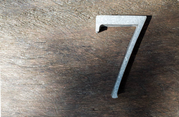 istock Number 7 (seven) made  from zinc on wood texture background 936129512