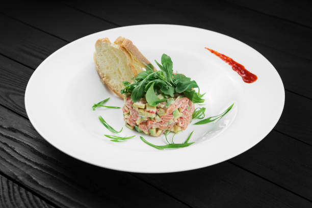 istock Salmon tartare with avocado on white plate. 936132486