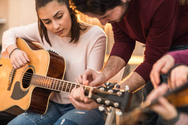 istock Young woman learning to play the guitar 936132550