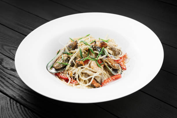 istock Pasta with shrimps and mussels on white plate. 936133206