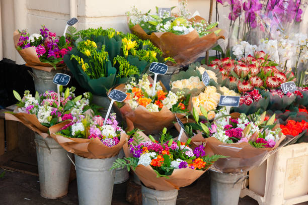 Flowers for sale at street market in England Various flower bouquets in baskets with price tags for sale at a street market in England flower market stock pictures, royalty-free photos & images