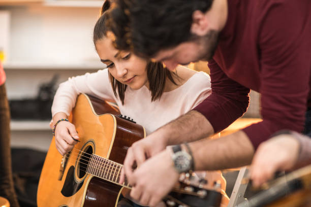 istock Young woman learning to play the guitar 936135760