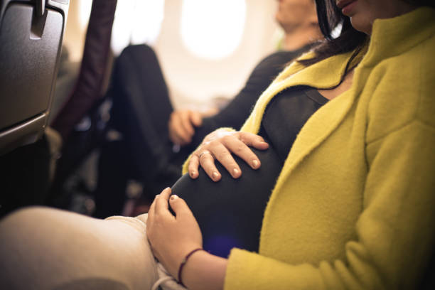 Pregnant woman traveling with airplane. Close up. stock photo
