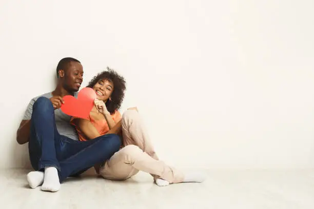 Photo of Happy african-american couple holding paper heart