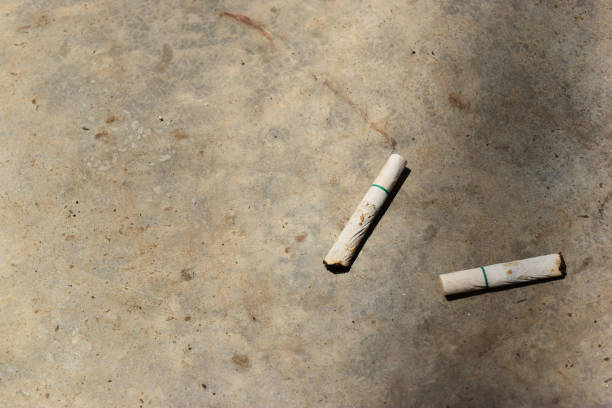 istock Two used cigarettes dropped on the cement floor . 936152488